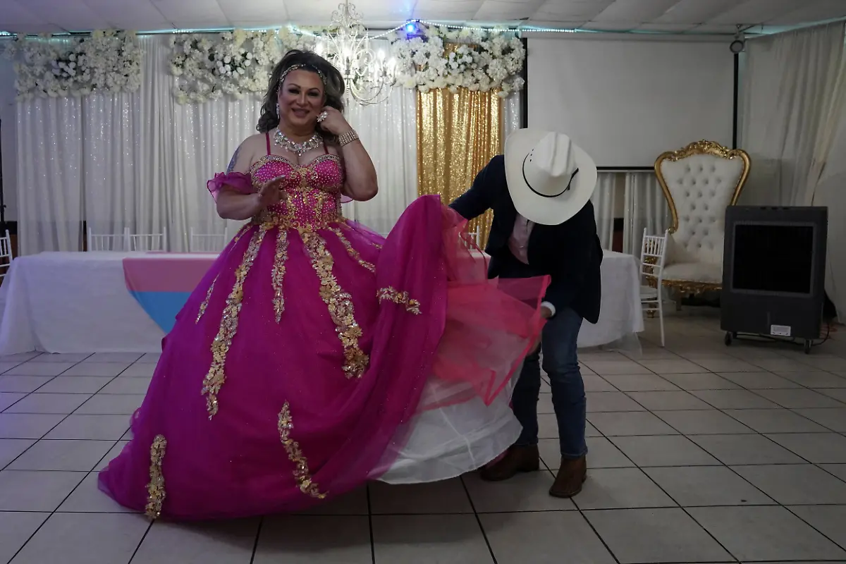 Kassandra-Rivas-51-gets-her-dress-fixed-by-makeup-artist-Anthony-Borjas-at-a-ballroom-in-Houston-Texas-U-S-May-14-2025-Rivas-and-other-transgender-Latina-immigrants-were-recently-able-to-celebrate-this-year-as-quinceaneras-thanks-to-the-Organizacion-Latina-de-Trans-en-Texas-a-group-promoting-rights-for-LGBTQ-people-including-transgender-women-from-Latin-America-Something-inside-me-held-a-longing-to-experience-this-moment-as-a-girl-as-a-15-year-old-Rivas-said-I-imagined-myself-standing-before-the-priest-in-church-wearing-a-dress-like-any-other-woman-REUTERS-Gabriel-V-Cardenas-SEARCH-CARDENAS-U-S-QUINCEANERAS-FOR-THIS-STORY-SEARCH-WIDER-IMAGE-FOR-ALL-STORIES-THIS-IMAGE-IS-ONLY-FOR-USE-WITH-THE-STORY-USA-LGBTQ-QUINCEANERAS-NO-STANDALONE-USES