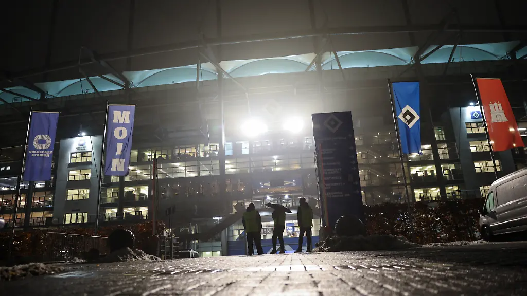 Fussball-Bundesliga-Mitarbeiter-einer-Sicherheitsfirma-stehen-auf-dem-Parkplatz-vor-dem-Volksparkstadion-Die-Bundesliga-Partie-zwischen-dem-Hamburger-SV-und-Bayer-Leverkusen-im-Volksparkstadion-ist-wegen-der-Folgen-des-Winterwetters-kurzfristig-abgesagt-worden