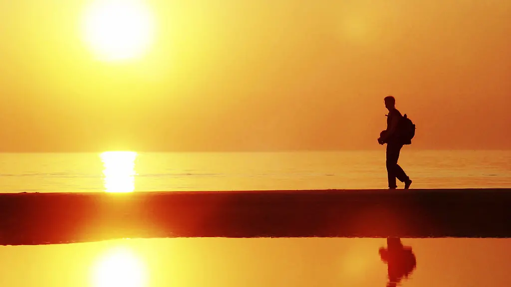 Junger-Mann-Silhouette-Wanderung-am-Meer-Sonnenuntergang-Urlaub-Freizeit-Frei-Friedlich-Sonne-MR-Yes-Wien-Oesterreich-Europa-Modellfreigabe-vorhanden