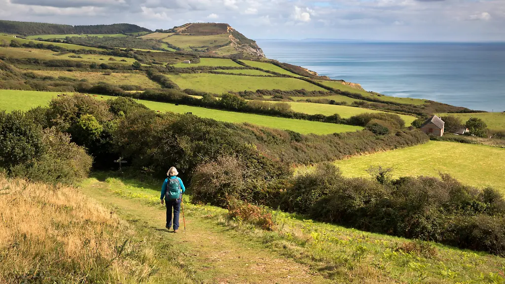 Walker-on-the-South-West-Coast-Path-near-Stonebarrow-with-Golden-Cap-in-distance-Charmouth-Jurassic-Coast-UNESCO-World-Heritage-Site-Dorset-England-United-Kingdom-Europe