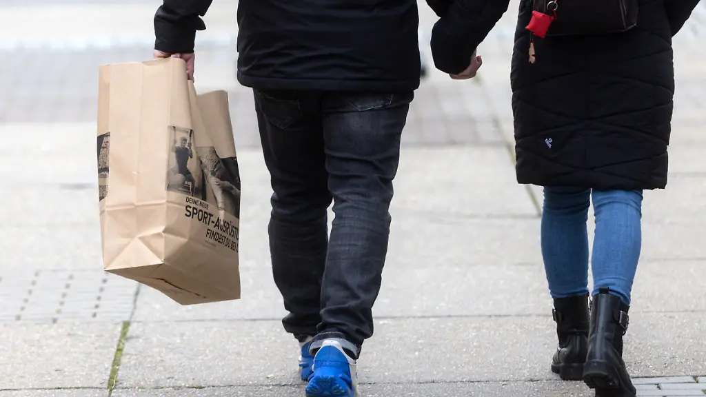 Passanten-mit-einer-Einkaufstuete-gehen-beim-verkaufsoffenen-Sonntag-am-1-Advent-in-Saalfeld-durch-die-Innenstadt-In-Thueringen-sind-nach-dem-Ladenoeffnungsgesetz-verkaufsoffene-Sonntage-am-1-oder-2-Advent-moeglich