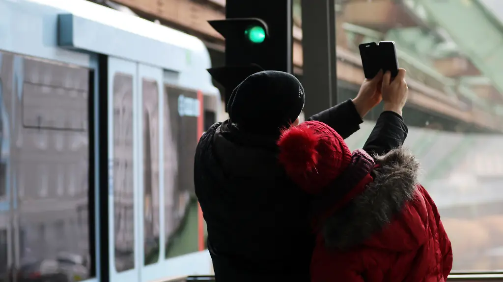 ARCHIV-Ein-Paar-macht-bei-der-Abfahrt-eines-neuen-Wagentyp-aus-einem-Bahnhof-der-Wuppertaler-Schwebebahn-am-18-12-2016-in-Wuppertal-Nordrhein-Westfalen-ein-Selfie-In-Brandenburg-kommt-es-immer-wieder-zu-lebensgefaehrlichen-Unfaellen-durch-leichtsinnige-Aktionen-zumeist-junger-Leute-an-Gleis-und-Bahnanlagen-zu-Immer-wieder-Unfaelle-durch-gefaehrlichen-Leichtsinn-in-Brandenburg-vom-13-05