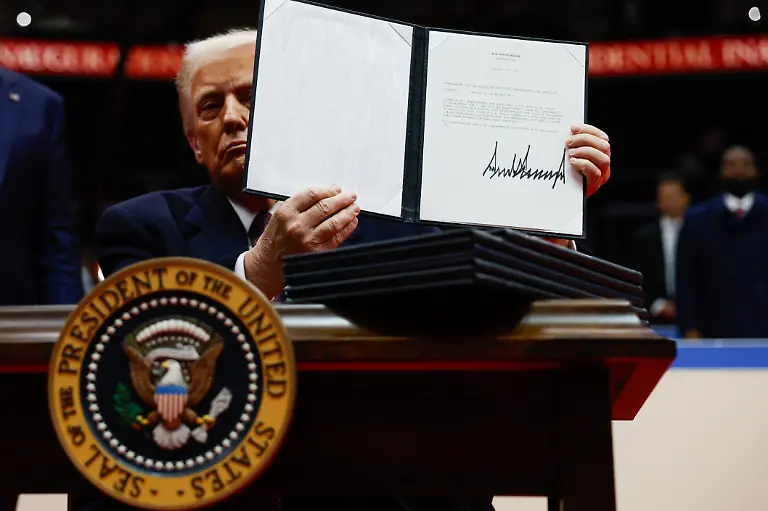 WASHINGTON-DC-JANUARY-20-U-S-President-Donald-Trump-holds-up-an-executive-order-after-signing-it-during-an-indoor-inauguration-parade-at-Capital-One-Arena-on-January-20-2025-in-Washington-DC-Donald-Trump-takes-office-for-his-second-term-as-the-47th-president-of-the-United-States
