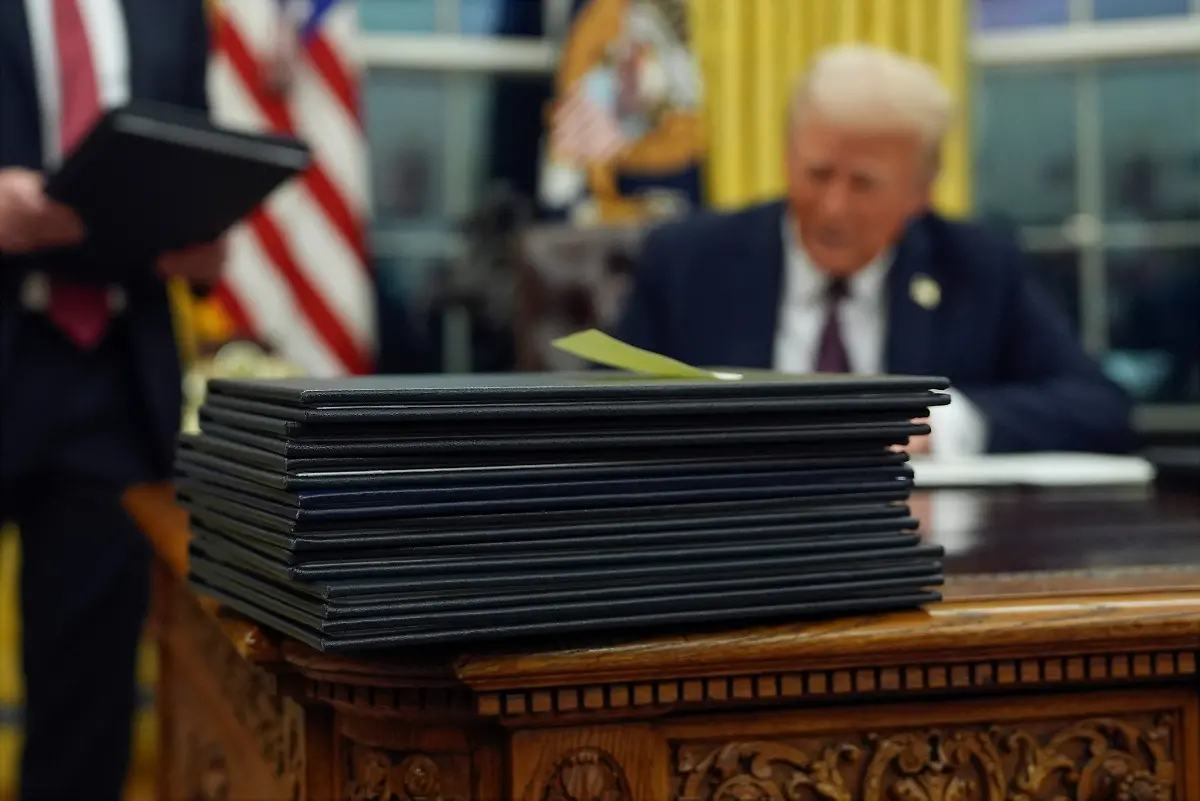 FILE-President-Donald-Trump-signs-executive-orders-in-the-Oval-Office-of-the-White-House-Jan-20-2025-in-Washington