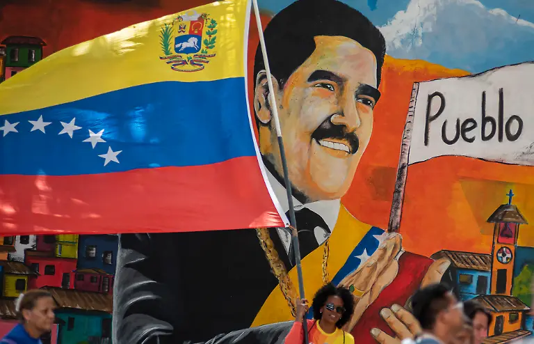Supporters-of-ousted-Venezuela-s-President-Nicolas-Maduro-carry-his-portrait-during-a-rally-outside-the-National-Assembly-in-Caracas-Venezuela-on-Monday-on-January-5-2026-Venezuela-s-parliament-swore-in-Delcy-Rodriguez-as-interim-president-on-January-5-two-days-after-US-forces-seized-her-predecessor-Nicolas-Maduro-to-face-trial-in-New-York-Members-of-the-new-National-Assembly-offered-their-full-backing-to-Rodriguez-who-had-been-Maduro-s-vice-president-and-reelected-her-brother-Jorge-Rodriguez-as-parliament-head