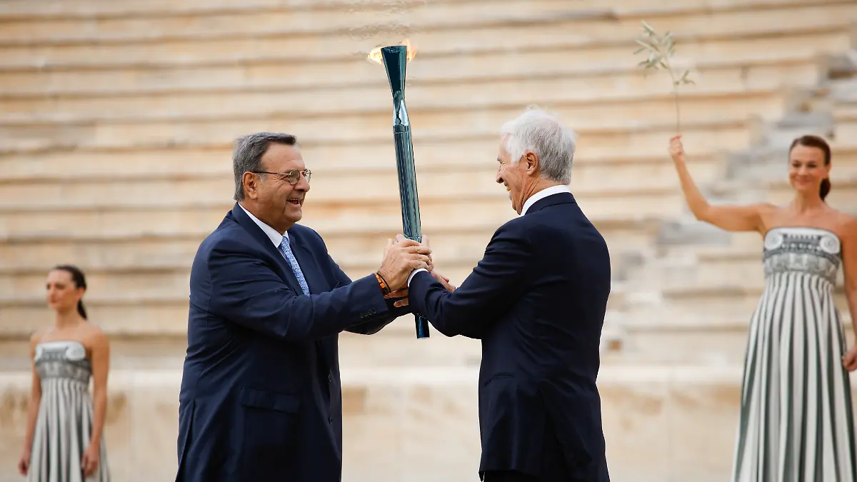 Der-Praesident-des-Griechischen-Olympischen-Komitees-Isidoros-Kouvelos-l-uebergibt-die-Fackel-an-den-Praesidenten-des-Organisationskomitees-Mailand-Cortina-Giovanni-Malago-waehrend-der-Uebergabezeremonie-der-Olympischen-Flamme-fuer-die-Olympischen-Winterspiele-2026-im-Panathinaiko-Stadion