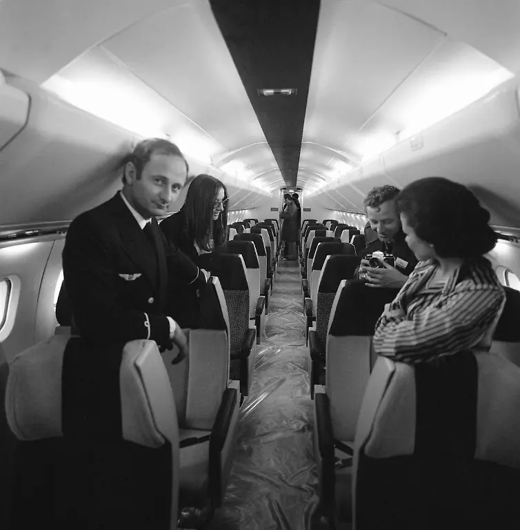 Passagierraum-in-der-Concorde-1976-Sachfoto-Sachaufnahme-Flugzeug-Flugzeuginneres-Crew-Kapitaen-Mann-mit-Fotoapparat-Kamera-Innenraum-Luftverkehr-Luftfahrt