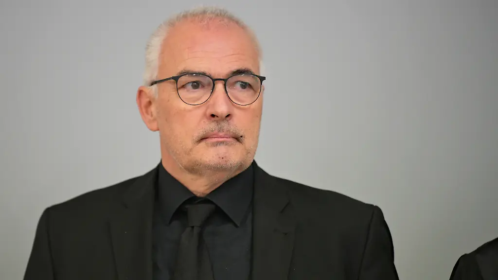 Der-Angeklagte-Axel-Fischer-Ex-CDU-Parlamentarier-aus-dem-Wahlkreis-Karlsruhe-Land-M-kommt-vor-Prozessbeginn-wegen-Bestechlichkeitsvorwuerfen-in-der-sogenannten-Aserbaidschan-Affaere-in-einen-Gerichtssaal-vom-Oberlandesgericht-In-einem-ersten-Prozess-hatte-das-Gericht-einen-Ex-CSU-Bundestagsabgeordneten-zu-einer-Freiheitsstrafe-von-neun-Monaten-auf-Bewaehrung-verurteilt-Fischer-war-auch-dort-bereits-angeklagt-gewesen-das-Gericht-hatte-den-Prozess-aber-dann-abgetrennt