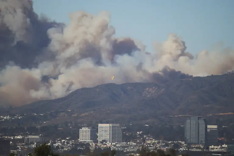 An-aircraft-flies-to-drop-fire-retardant-over-the-area-of-a-wildfire-burning-near-Pacific-Palisades-on-the-west-side-of-Los-Angeles-during-a-weather-driven-windstorm-in-Los-Angeles-California-January-7-2025