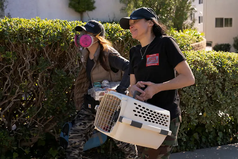 Maggie-Feldman-and-Shyann-Swisher-with-Animal-Advocacy-Network-carry-a-resident-s-two-cats-while-retrieving-pets-for-evacuated-residents-in-an-area-affected-by-the-Palisades-Fire-near-Pacific-Palisades-in-Los-Angeles-California-U-S-January-12-2025
