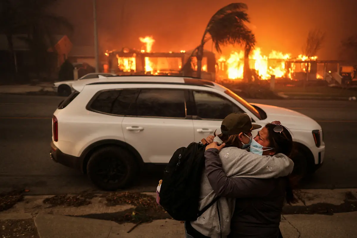 People-embrace-as-they-evacuate-following-powerful-winds-fueling-devastating-wildfires-in-the-Los-Angeles-area-at-the-Eaton-Fire-in-Altadena-California-U-S-January-8-2025-REUTERS-David-Swanson-SEARCH-CALIFORNIA-WILDFIRES-FOR-THIS-STORY-SEARCH-WIDER-IMAGE-FOR-ALL-STORIES