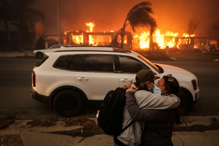 People-embrace-as-they-evacuate-following-powerful-winds-fueling-devastating-wildfires-in-the-Los-Angeles-area-at-the-Eaton-Fire-in-Altadena-California-U-S-January-8-2025-REUTERS-David-Swanson-SEARCH-CALIFORNIA-WILDFIRES-FOR-THIS-STORY-SEARCH-WIDER-IMAGE-FOR-ALL-STORIES