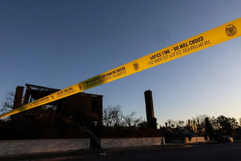 A-police-yellow-tape-installed-to-restrict-the-access-of-an-area-damaged-by-the-Palisades-Fire-is-seen-at-the-Pacific-Palisades-neighborhood-in-Los-Angeles-California-U-S-January-13-2025