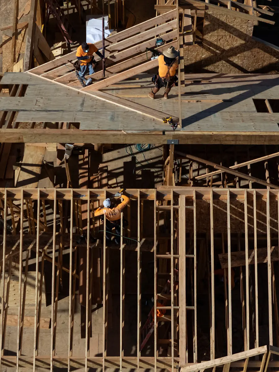 A-drone-view-of-workers-constructing-a-house-in-the-Pacific-Palisades-neighborhood-months-after-wildfires-in-January-devastated-the-area-in-Los-Angeles-California-December-11-2025