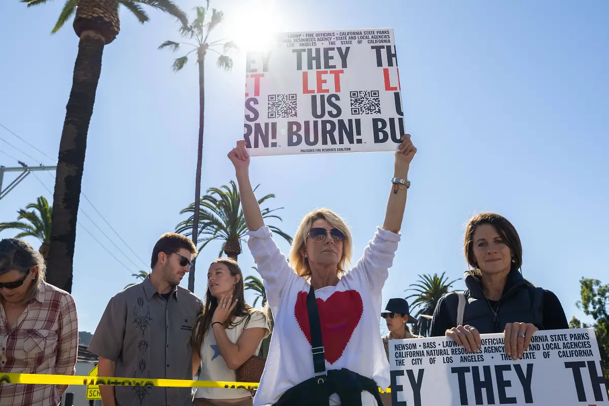 A-demonstrator-holds-a-sign-during-a-rally-marking-the-first-anniversary-of-the-deadly-Palisades-fire-in-the-Pacific-Palisades-neighborhood-of-Los-Angeles-on-Jan-7-2026