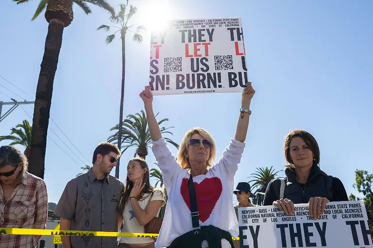 A-demonstrator-holds-a-sign-during-a-rally-marking-the-first-anniversary-of-the-deadly-Palisades-fire-in-the-Pacific-Palisades-neighborhood-of-Los-Angeles-on-Jan-7-2026