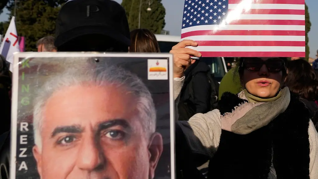 Demonstrators-show-placards-with-the-US-flag-and-of-of-Iran-s-exiled-crown-prince-Reza-Pahlavi-during-a-rally-in-support-of-the-Iranian-people-in-Rome-Saturday-Jan-17-2026
