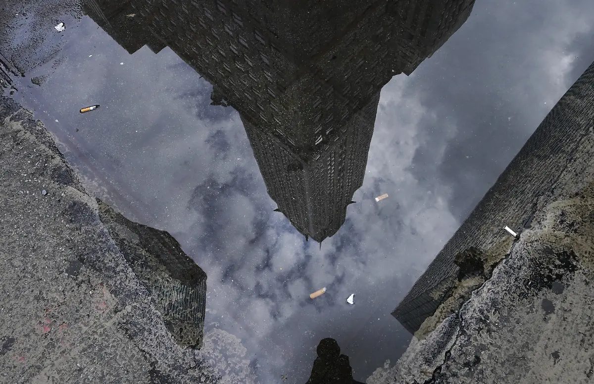 The-Chrysler-Building-Art-Decostyle-skyscraper-in-Midtown-Manhattan-is-reflected-in-a-puddle-of-water-on-Lexington-Avenue-in-New-York-July-31-2020-after-storms-came-through-the-area-this-morning-Photo-by-TIMOTHY-A