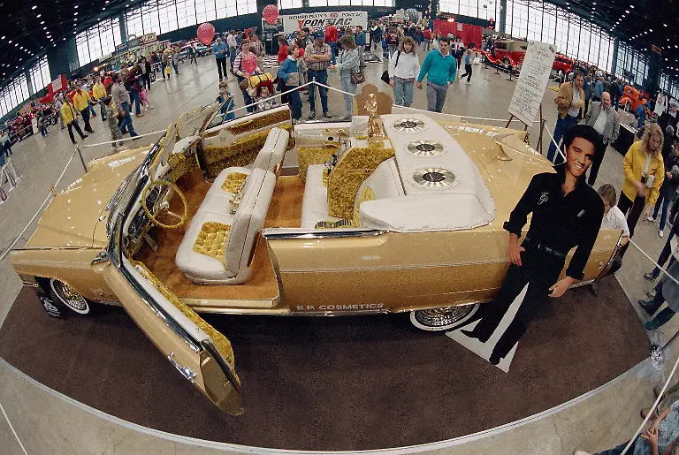 Crowds-at-an-auto-show-look-at-a-custom-made-1965-gold-Cadillac-Eldorado-designed-by-George-Barris-and-Elvis-Presley-in-Chicago-Jan-17-1987-The-car-designed-before-Presley-s-death-has-three-gold-Elvis-Presley-45-rpm-records-imbedded-in-the-rear-headrest-and-has-a-body-telephone-television-bumpers-and-grill-covered-with-14-karat-gold-leaf-The-car-is-touring-the-country-appearing-at-malls-and-auto-shows