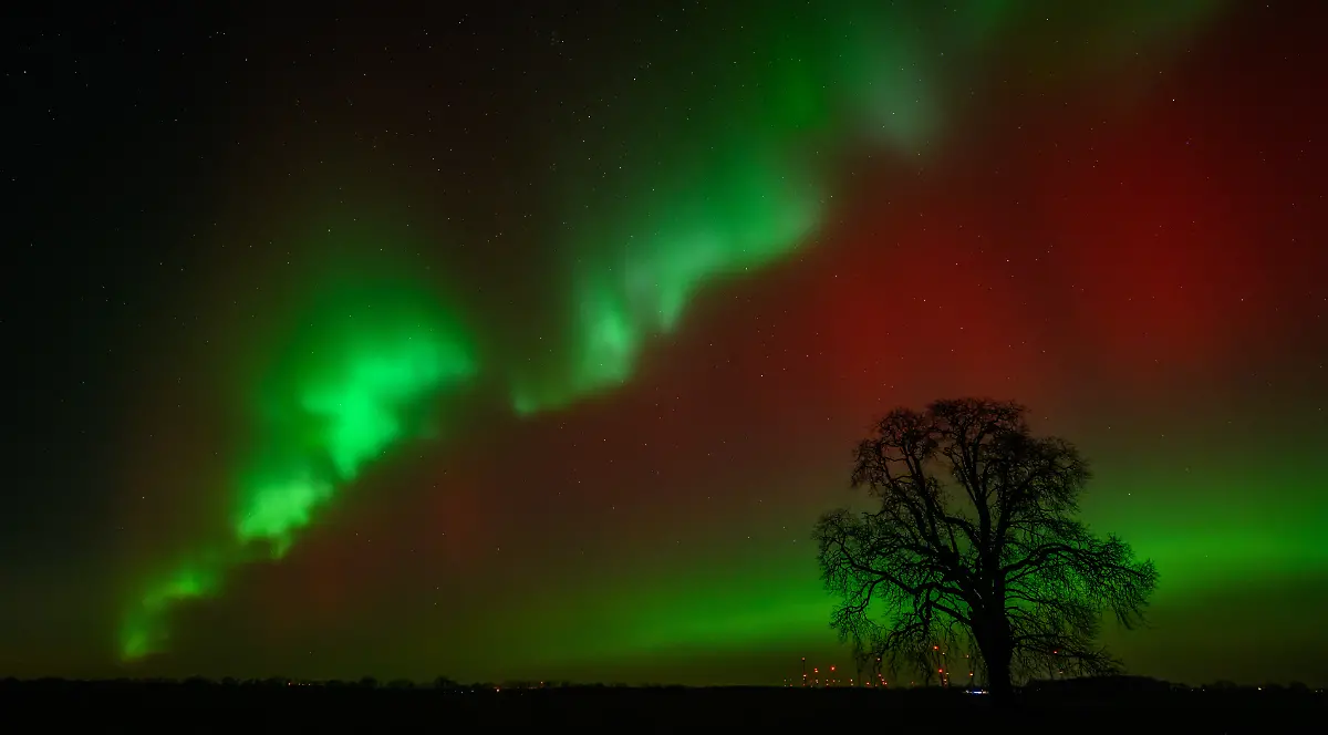 Polarlichter-leuchten-am-Nachthimmel-ueber-der-Landschaft-im-oestlichen-Brandenburg-Dieses-Nordlicht-Aurora-borealis-wurde-durch-eine-Wolke-elektrisch-geladener-Teilchen-eines-Sonnensturms-in-der-Erdatmosphaere-erzeugt