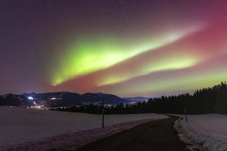 Polarlichter-sind-in-der-Nacht-ueber-der-Landschaft-im-Oberallgaeu-mit-den-Bergen-der-Hoernerkette-zu-sehen