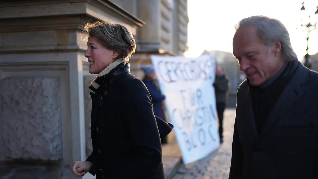 Christina-Block-deutsche-Gastronomin-und-Unternehmerin-und-Gerhard-Delling-ehemaliger-Sportmoderator-und-Lebensgefaehrte-von-Block-gehen-zu-einem-weiteren-Verhandlungstag-im-Prozess-wegen-mutmasslicher-Kindesentfuehrung-in-das-Strafjustizgebaeude-vorbei-an-Demonstranten-In-einer-Nacht-und-Nebel-Aktion-wurden-in-der-Silvesternacht-2023-24-zwei-Kinder-der-Gastronomie-Unternehmerin-C-Block-von-Daenemark-nach-Deutschland-gebracht-Wegen-der-mutmasslichen-Entfuehrung-findet-am-Landgericht-Hamburg-der-Prozess-statt-unter-anderem-gegen-Block