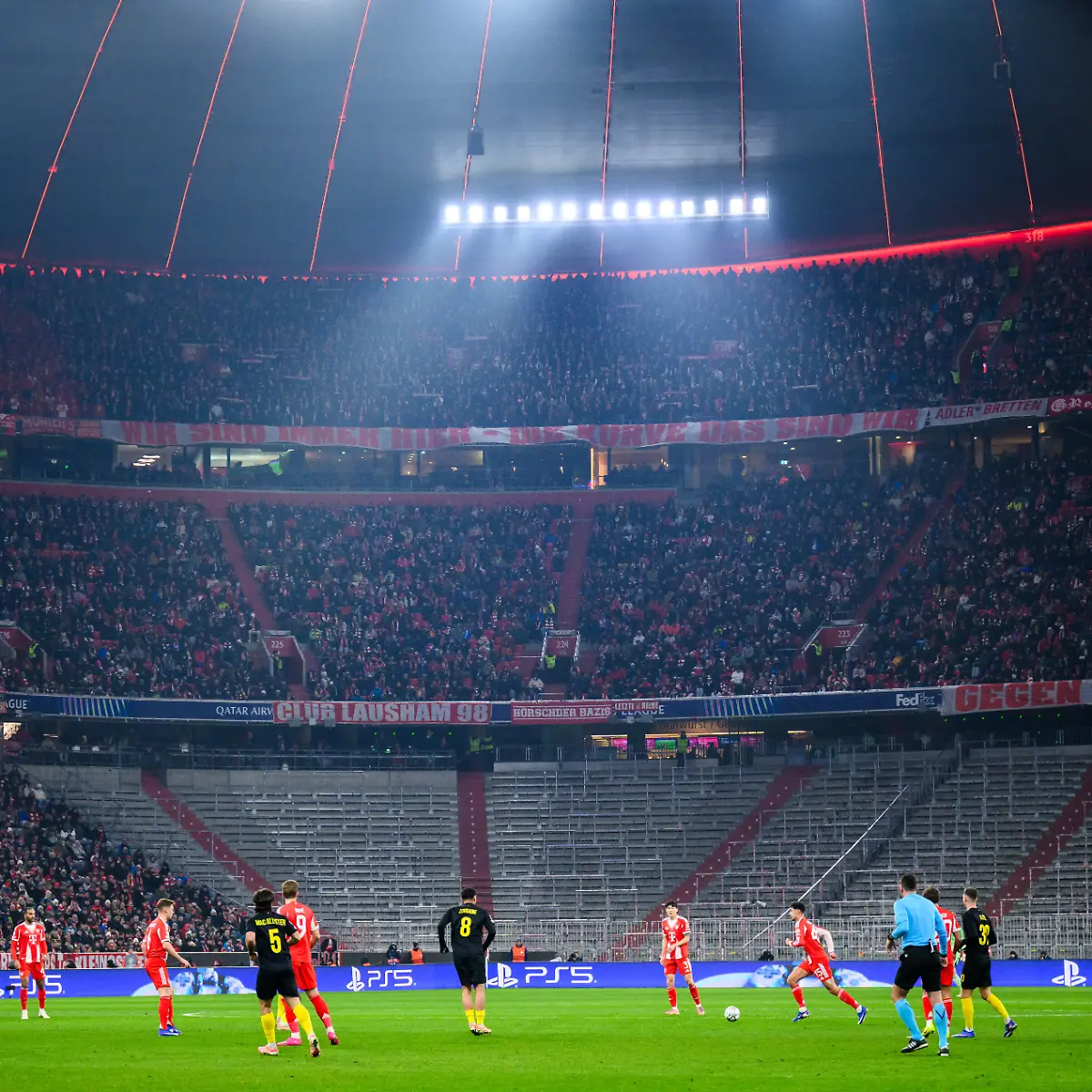 Fussball-Champions-League-Bayern-Muenchen-Union-St-Gilloise-Vorrunde-7-Spieltag-Allianz-Arena-Zuschauer-sitzen-oder-stehen-links-und-oberhalb-der-leeren-Suedkurve-Die-UEFA-hatte-nach-erneuten-Pyrotechnik-Vorfaellen-eine-Sperrung-der-Bloecke-111-bis-114-verhaengt-die-der-Klub-aus-organisatorischen-Gruenden-auf-den-gesamten-Unterrang-ausgeweitet-hat