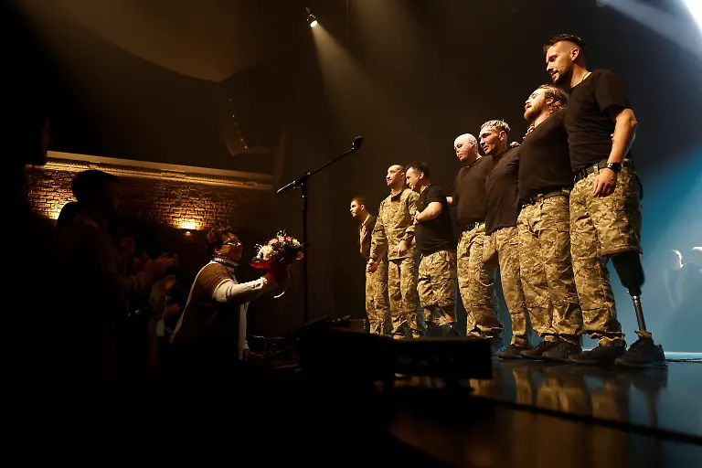 A-person-gives-flowers-to-the-Veterans-Theatre-group-at-the-end-of-the-premiere-of-an-18th-century-Ukrainian-parody-of-Virgil-s-Aeneid-amid-Russia-s-attack-on-Ukraine-in-Kyiv-Ukraine-December-4-2025-Fellow-member-and-veterans-psychologist-Yehor-Babenko-27-said-the-transformative-trauma-of-serious-injury-often-compels-people-to-seek-meaning-in-something-new-He-said-it-was-critical-for-his-fellow-comrades-to-understand-that-life-does-not-simply-end-after-a-serious-injury-Sometimes-you-understand-it-s-the-opposite-that-it-just-starts-getting-going-REUTERS-Alina-Smutko-SEARCH-UKRAINE-SMUTKO-THEATRE-FOR-THIS-STORY-SEARCH-WIDER-IMAGE-FOR-ALL-STORIES