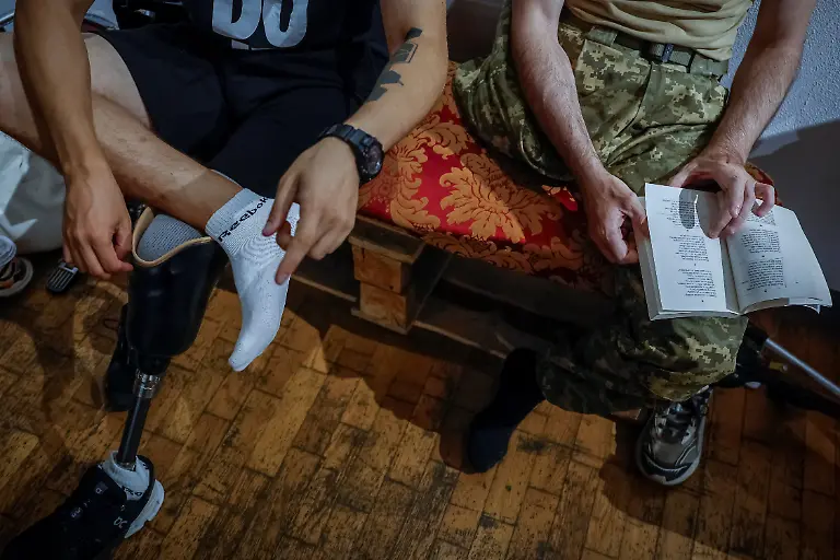 Roman-Trokhymenko-right-57-who-lost-his-right-leg-in-2024-and-fellow-member-of-the-Veteran-s-Theatre-group-Ivan-Voinov-33-read-the-original-text-of-Ivan-Kotliarevskyi-s-Eneida-before-rehearsing-for-an-18th-century-Ukrainian-parody-of-Virgil-s-Aeneid-amid-Russia-s-attack-on-Ukraine-in-Kyiv-Ukraine-September-7-2025-Like-the-other-veterans-in-his-Kyiv-based-group-of-around-15-actors-Trokhymenko-has-found-healing-and-fulfilment-on-stage-participating-in-the-theatre-has-helped-reinforce-the-confidence-he-has-tried-hard-to-maintain-since-his-injury-REUTERS-Alina-Smutko-SEARCH-UKRAINE-SMUTKO-THEATRE-FOR-THIS-STORY-SEARCH-WIDER-IMAGE-FOR-ALL-STORIES