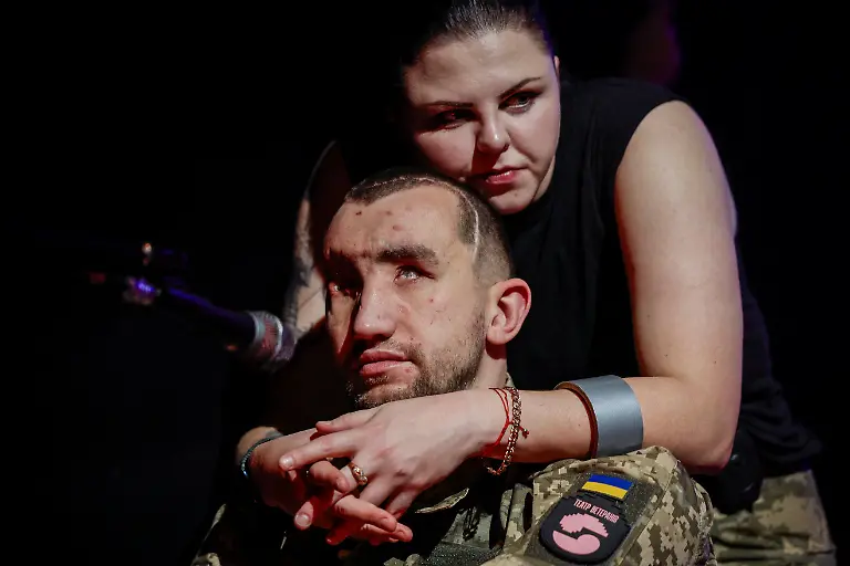 Inna-Korolenko-26-hugs-fellow-veteran-Andrii-Onopriienko-31-who-lost-both-eyes-when-two-Russian-anti-tank-rounds-struck-his-position-in-the-eastern-city-of-Avdiivka-in-2023-during-rehearsal-with-the-Veterans-Theatre-for-an-18th-century-Ukrainian-parody-of-Virgil-s-Aeneid-amid-Russia-s-attack-on-Ukraine-in-Kyiv-Ukraine-December-4-2025-Like-the-other-veterans-in-his-Kyiv-based-group-of-around-15-actors-Onopriienko-has-found-healing-and-fulfilment-on-stage-after-a-friend-told-him-about-a-theatre-looking-for-injured-veterans-and-suggested-he-join-Yes-we-might-not-have-an-arm-or-legs-or-eyes-but-we-aren-t-giving-up-he-said-It-s-rehabilitation-and-socialisation-it-s-positive-emotions-REUTERS-Alina-Smutko-SEARCH-UKRAINE-SMUTKO-THEATRE-FOR-THIS-STORY-SEARCH-WIDER-IMAGE-FOR-ALL-STORIES