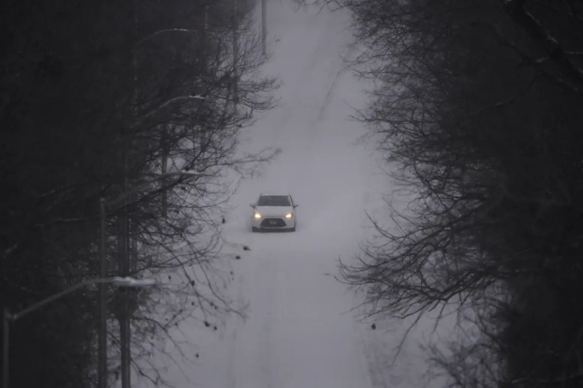 A-motorist-drives-down-a-snow-covered-street-as-a-winter-storm-passes-though-the-area-Saturday-Jan-24-2026-in-Kansas-City-Mo