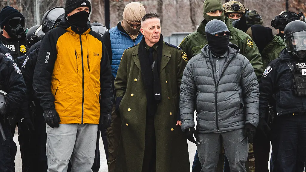 January-15-2026-Minneapolis-Minnesota-USA-Border-Chief-GREGORY-BOVINO-observes-a-protest-as-community-members-gather-at-the-entrance-of-the-Whipple-Building-in-Minneapolis-to-rally-in-solidarity-with-their-neighbors-whom-are-being-detained-by-U-S
