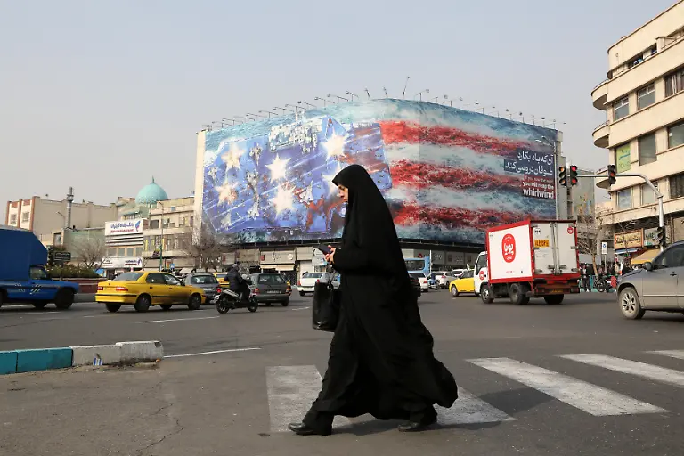 TEHRAN-IRAN-JANUARY-25-A-giant-banner-depicting-a-U-S-aircraft-carrier-and-the-American-flag-was-displayed-at-Enqelab-Revolution-Square-in-Tehran-Iran-amid-rising-tensions-between-the-United-States-and-Iran-on-January-25-2026-The-banner-featured-the-phrase-If-you-saw-the-wind-you-will-reap-the-whirlwind-written-in-both-English-and-Persian-targeting-the-deployment-of-the-USS-Abraham-Lincoln-aircraft-carrier-to-the-Middle-East-which-was-announced-by-U-S-President-Donald-Trump