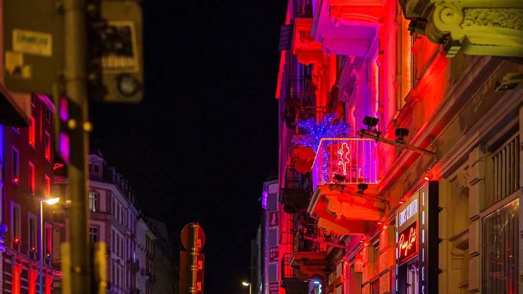 Die-rot-beleuchtete-Hausfassade-weisst-auf-koerpernahe-Dienstleistungen-hin-Das-Bahnhofsviertel-gilt-auch-als-Problemviertel-Es-hat-diesen-Ruf-aufgrund-von-Drogenhandel-offener-Drogenszene-Prostitution-illegalem-Gluecksspiel-und-Kriminalitaet-wie-Raubueberfaellen-und-Beschaffungskriminalitaet
