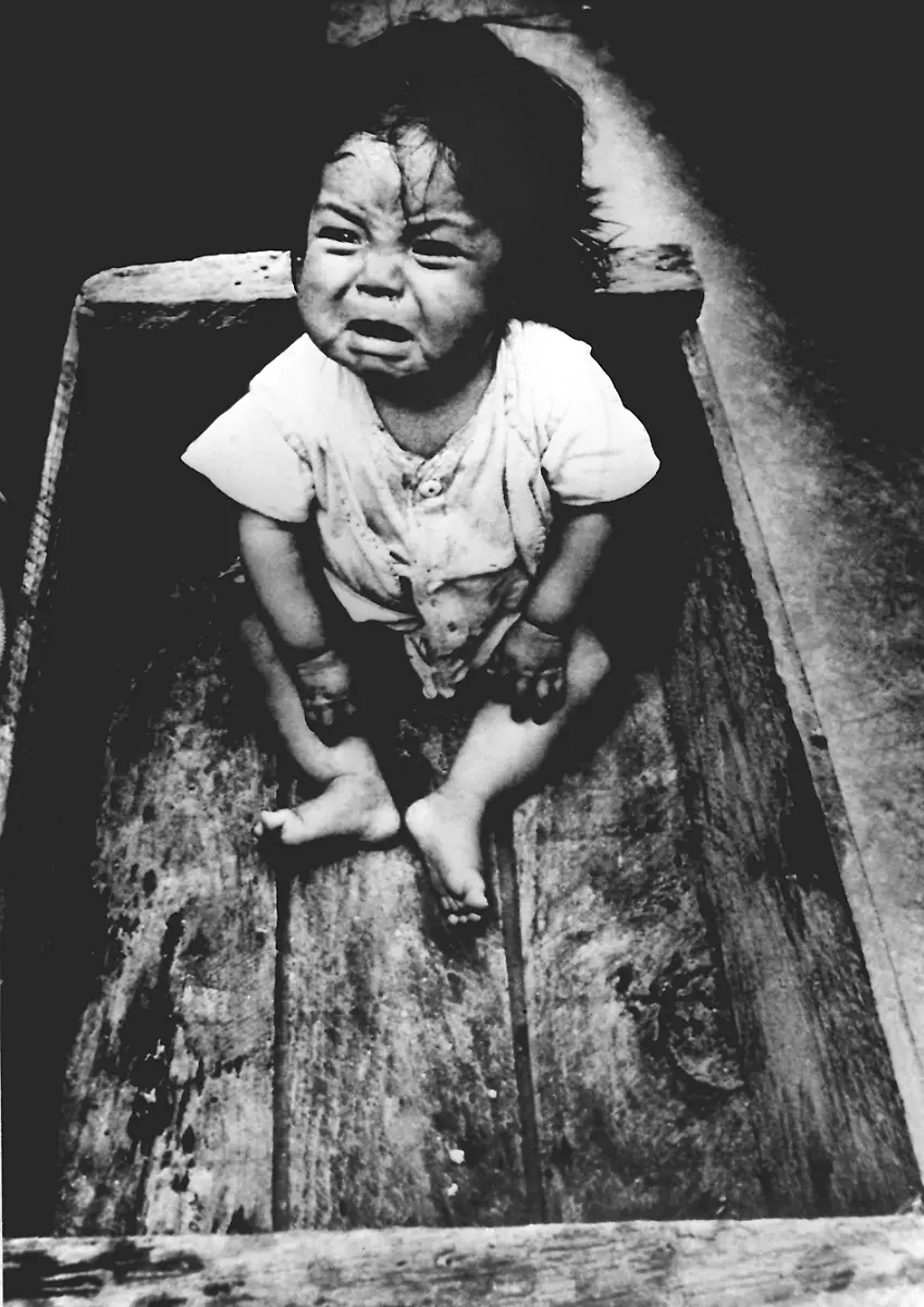 Ein-kleines-Kind-das-seine-Eltern-bei-dem-Erdbeben-verloren-hat-schreit-in-einer-Holzkiste-nach-Aufmerksamkeit-aufgenommen-im-Maerz-1976-Etwa-4000-Kinder-machte-das-Erdbeben-zu-Waisen-Bei-dem-Erdbeben-vom-4-Februar-1976-in-Guatelmala-sind-22-500-Menschen-ums-Leben-gekommen