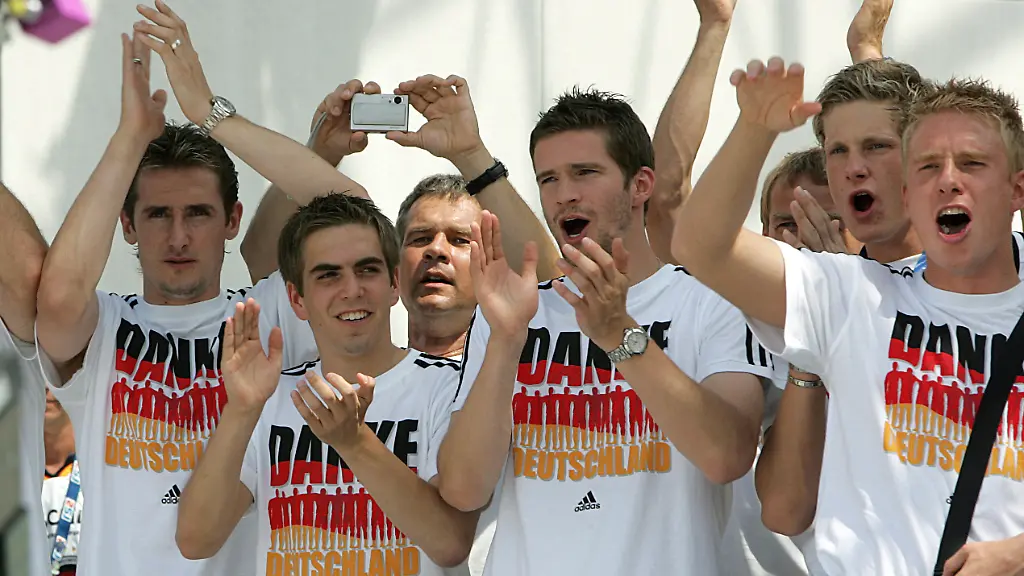 Die-Spieler-der-deutschen-Fussball-Nationalmannschaft-Miroslav-Klose-l-r-Philipp-Lahm-Arne-Friedrich-Marcell-Jansen-und-Mike-Hanke-feiern-am-Sonntag-09-07-2006-auf-der-Hauptbuehne-der-Fanmeile-am-Brandenburger-Tor-in-Berlin-Hunderttausende-empfingen-das-Team-in-der-Bundeshauptstadt