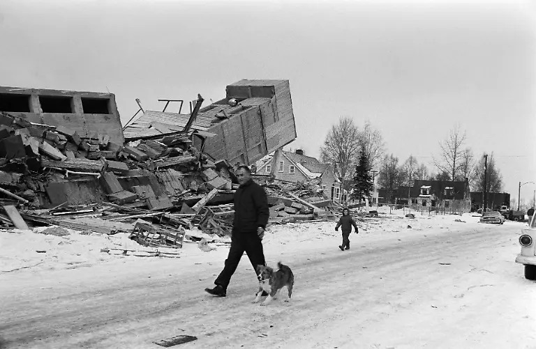 Residents-of-Alaska-walk-the-streets-of-Anchorage-Alaska-on-March-30-1964-amid-ruins-caused-by-the-March-27-1964-earthquake-that-left-131-victims-and-caused-a-tsunami-that-killed-14-people-in-California-and-caused-damage-across-the-entire-American-west-coast-The-1964-earthquake-in-Alaska-is-one-of-the-most-powerful-earthquakes-ever-recorded-in-the-world-with-a-magnitude-9-2-between-9-1-and-9-3-on-the-Richter-scale-and-the-second-largest-earthquake-after-an-M9-5-earthquake-in-Chile-in-1960