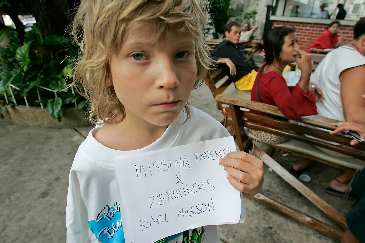 FOR-USE-AS-DESIRED-PHOTOS-OF-THE-DECADE-FILE-Karl-Nilsson-of-Lulo-Sweden-poses-with-a-sign-saying-his-parents-and-brothers-are-missing-in-this-Dec-28-2004-file-photo-in-Phuket-Thailand-The-young-boys-parents-were-swept-out-to-sea-Sunday-Dec-26-2004-when-the-tsunami-struck-their-beach-hotel-just-north-of-Phuket-Thailand-The-total-toll-of-dead-and-missing-from-last-year-s-Indian-Ocean-tsunami-is-at-least-216-858-according-to-government-and-aid-agency-figures-although-different-agencies-in-Indonesia-and-Sri-Lanka-are-reporting-different-numbers