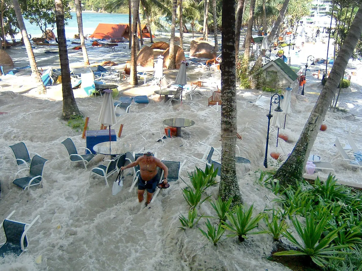 Die-durch-das-Seebeben-ausgeloeste-Flutwelle-ueberschwemmt-am-27-12-2004-das-Gelaende-des-Le-Meridien-Hotels-in-Khao-Lak-Ein-Mann-versucht-sich-in-Sicherheit-zu-bringen-Mehrere-Tage-nach-der-Zerstoerung-des-thailaendischen-Luxushotels-Magic-Lagoon-bei-Khao-Lak-sind-am-30-12-weitere-21-Hotelgaeste-lebend-gefunden-worden-Damit-seien-mindestens-206-der-415-zumeist-aus-Deutschland-stammenden-Urlauber-am-Leben-teilte-der-Hotelkonzern-Accor-am-30-12-in-Paris-mit-Von-den-320-Hotelangestellten-von-denen-250-zum-Zeitpunkt-des-Ungluecks-Dienst-hatten-seien-mindestens-221-am-Leben-70-Prozent-der-Hotelgaeste-waren-Deutsche
