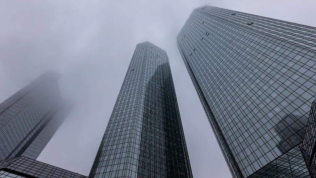10-11-25-Frankfurt-Symbolfoto-Illustrationsbild-Symbolbild-Illustrationsfoto-Alltagsszene-Blick-auf-die-Zwillingstuerme-der-Deutschen-Bank-in-Frankfurt-am-Main-an-einem-nebligen-Herbsttag-Die-Glasfassaden-der-Hochhaeuser-ragen-in-den-grauen-Himmel-waehrend-herbstliche-Baeume-und-die-geometrische-Linienfuehrung-des-unteren-Gebaeudeteils-das-Bild-ergaenzen-Eine-ruhige-klare-Stadtaufnahme-die-die-moderne-Architektur-des-Frankfurter-Bankenviertels-betont