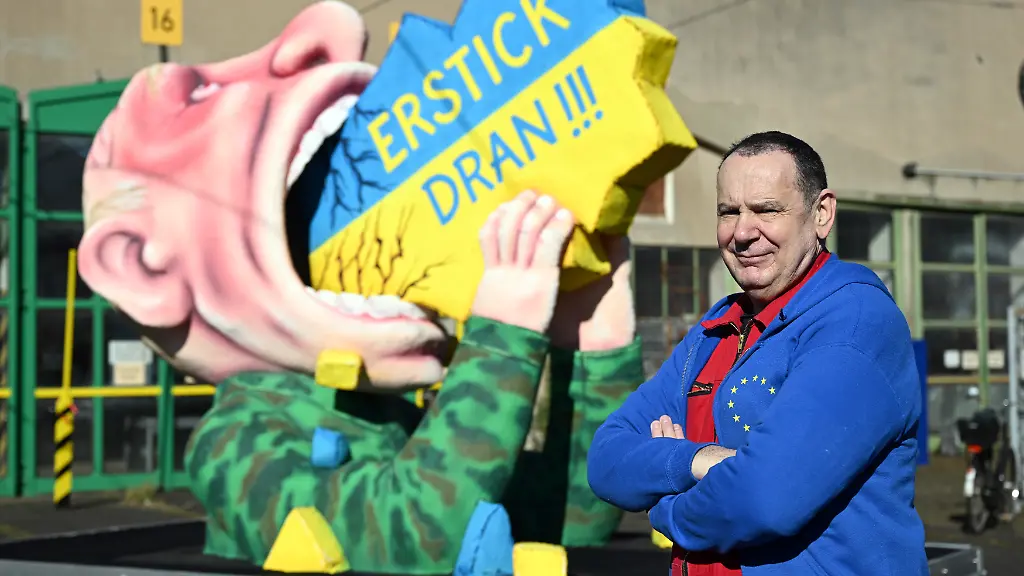 Jacques-Tilly-Wagenbauer-steht-vor-einem-Motivwagen-mit-dem-russischen-Praesidenten-Putin-der-die-Ukraine-schluckt-Wagenbauer-Jacques-Tilly-will-am-heutigen-Rosenmontag-einen-eigens-angefertigten-Karnevalswagen-zum-Ukraine-Krieg-durch-die-Stadt-rollen-lassen