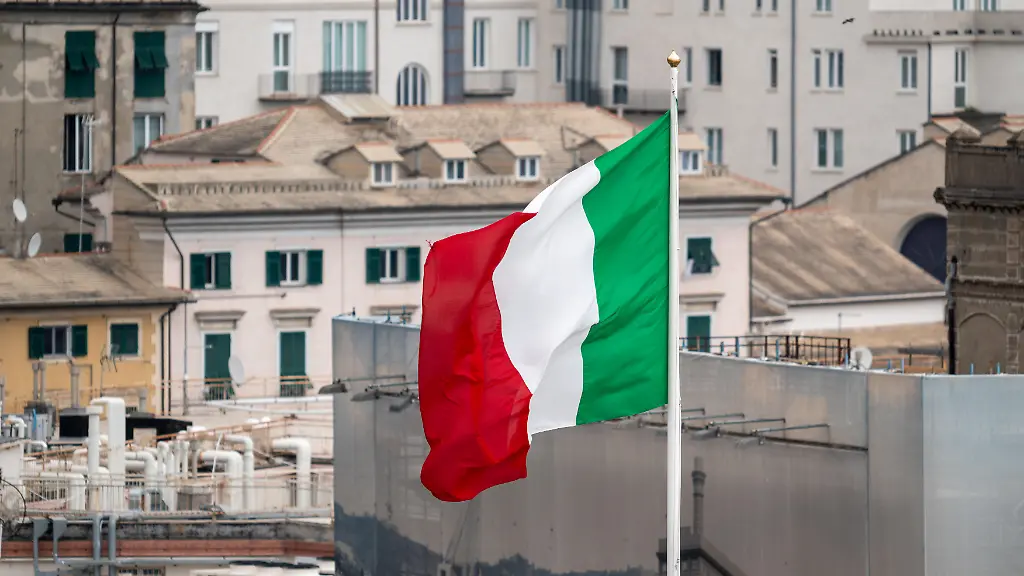 Die-italienische-Nationalflagge-weht-im-Wind-ueber-dem-Hafen-von-Genua