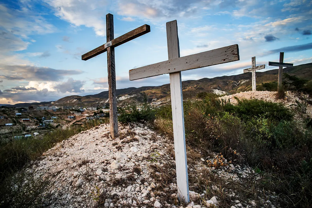 December-14-2019-Port-au-Prince-Haiti-Several-crosses-overlook-the-memorial-and-the-villages-that-have-sprung-up-since-people-moved-there-from-temporary-shelters-after-the-earthquake-The-St-Christophe-settlement-at-Titanyen-is-located-where-the-January-12-2012-memorial-is-located-Over-10-000-people-are-buried-here-in-mass-graves-after-the-2010-earthquake-The-memorial-is-a-sad-and-neglected-homage-to-all-who-died-without-being-claimed-by-family-members