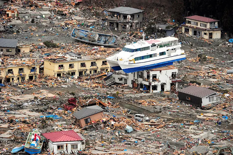 epa02634265-A-ship-is-seen-perched-on-top-of-a-house-in-the-tsunami-devastated-remains-of-Otsuchi-Iwate-prefecture-Japan-15-March-2011-An-8-9-magnitude-earthquake-and-devastating-tsunami-rocked-north-eastern-Japan-killing-well-over-1-000-people-the-government-said