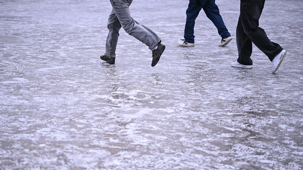Jugendliche-rutschen-ueber-die-vereiste-Flaeche-vor-dem-Reichstagsgebaeude