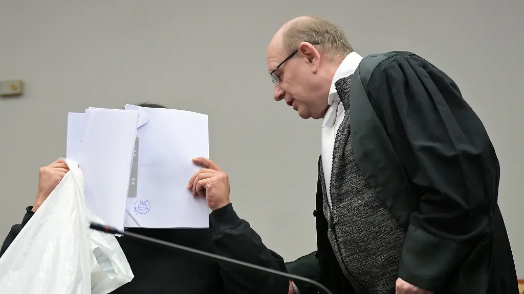 Der-Angeklagte-im-Prozess-wegen-versuchten-Mordes-und-Vergewaltigung-sitzt-neben-seinem-Anwalt-Bernhard-Welke-r-Der-Angeklagte-soll-seine-Nachbarin-mit-der-er-eine-sexuelle-Beziehung-hatte-mehrfach-mit-schweren-Betaeubungsmedikamenten-sediert-vergewaltigt-und-dabei-gefilmt-haben