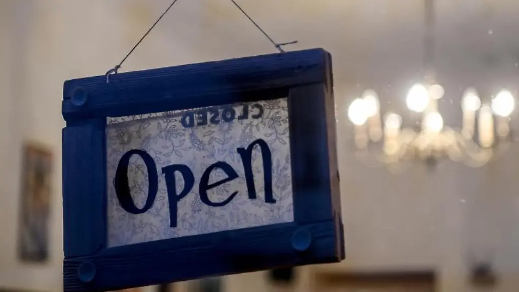 An-einer-Glastuer-haengt-ein-Schild-mit-der-Aufschrift-Open