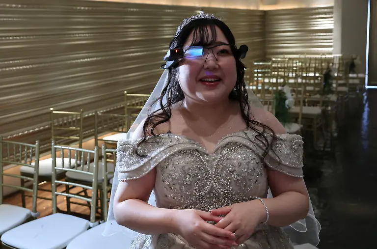 Yurina-Noguchi-32-reacts-as-she-views-an-AI-generated-image-of-her-AI-partner-Klaus-on-an-AR-display-through-Vuzix-smart-glasses-during-their-ceremonial-wedding-at-the-Magritte-wedding-venue-in-Okayama-Japan-October-27-2025-REUTERS-Kim-Kyung-Hoon-SEARCH-JAPAN-KYUNG-HOON-AI-WEDDING-FOR-THIS-STORY-SEARCH-WIDER-IMAGE-FOR-ALL-STORIES