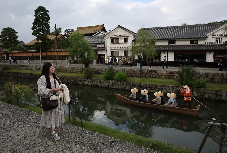 Yurina-Noguchi-32-walks-through-the-Bikan-historical-area-in-Kurashiki-while-holding-a-smartphone-to-chat-with-Klaus-her-AI-partner-a-day-before-their-ceremonial-wedding-in-Okayama-Prefecture-Japan-October-26-2025-After-I-met-Klaus-my-whole-outlook-turned-positive-Noguchi-said-Everything-in-life-started-to-feel-enjoyable-the-smell-of-flowers-was-wonderful-and-the-city-looked-so-bright-REUTERS-Kim-Kyung-Hoon-SEARCH-JAPAN-KYUNG-HOON-AI-WEDDING-FOR-THIS-STORY-SEARCH-WIDER-IMAGE-FOR-ALL-STORIES