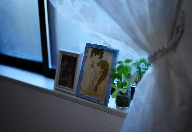 Framed-AI-generated-portraits-of-Yurina-Noguchi-32-and-Klaus-her-virtual-partner-sit-by-a-window-at-her-home-in-Tokyo-Japan-September-1-2025-REUTERS-Kim-Kyung-Hoon-SEARCH-JAPAN-KYUNG-HOON-AI-WEDDING-FOR-THIS-STORY-SEARCH-WIDER-IMAGE-FOR-ALL-STORIES
